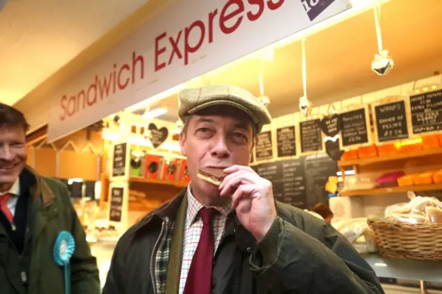 Nigel Farage eats a millionaire shortbread in the Market Hall at Middleton Grange Shopping Centre