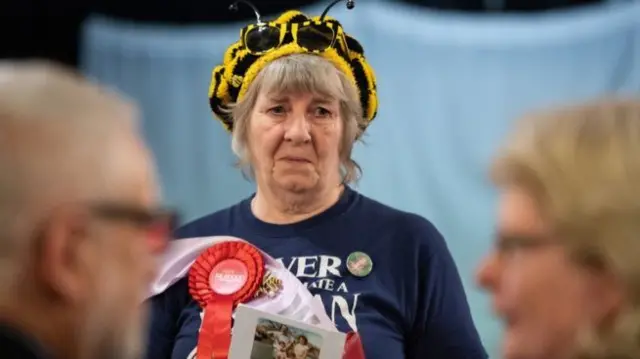 A woman wearing a yellow and black striped hat