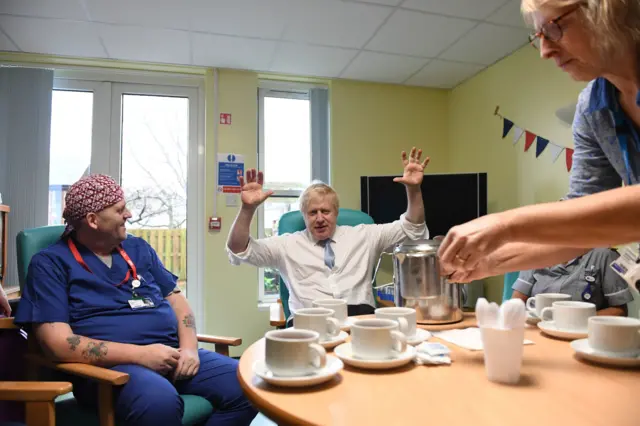 Here, an animated Mr Johnson has tea with staff members