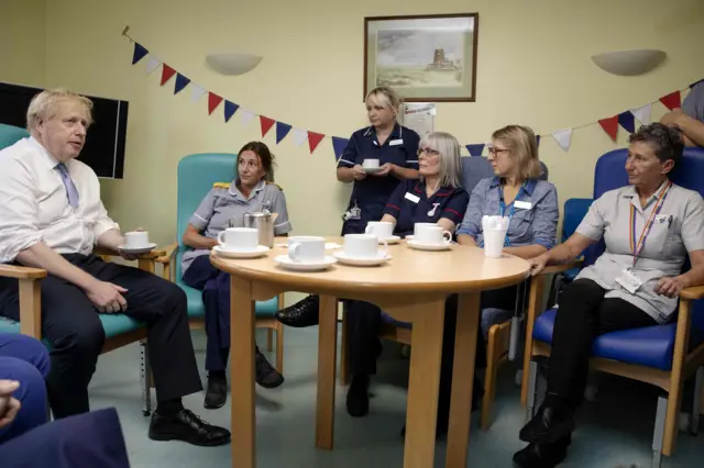 Britain"s Prime Minister Boris Johnson has a cup of tea and a chat with staff during an election campaign visit to West Cornwall Community hospital in Penzance, Cornwall