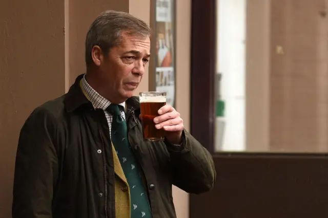 Brexit Party leader Nigel Farage drinks a pint of beer in a pub in Hull, north-east England while on the campaign trail on November 28, 2019.