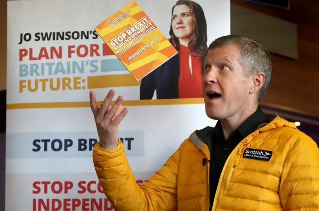 Willie Rennie throws a copy of his party"s Scottish Liberal Democrat manifesto for the December 12 General Election in the air at Murrayfield Curling Rink, Edinburgh