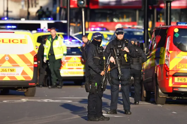 Armed police officers stand guard