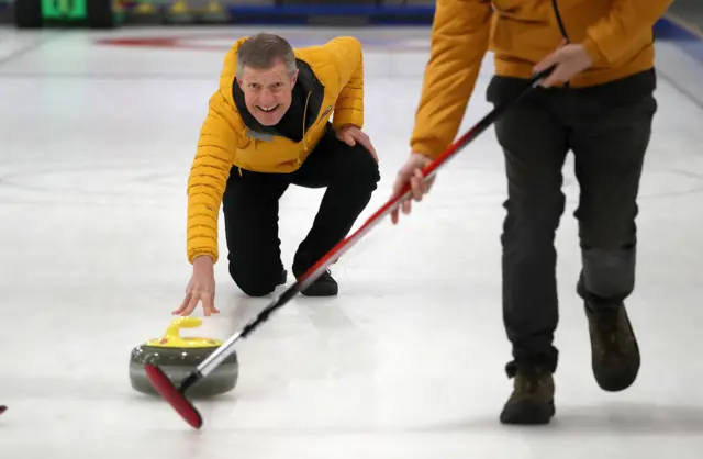 Willie Rennie throws a curling stone at Murrayfield Curling Rink in Edinburgh as he launches his party"s Scottish Liberal Democrat manifesto