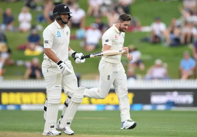 New Zealand's Ross Taylor walks off the pitch after his wicket while England's Chris Woakes