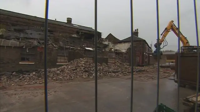 A digger at work demolishing part of the building on Saturday