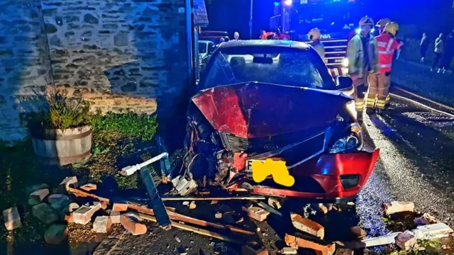 Car surrounded by bricks after crash