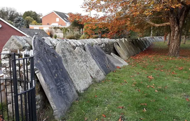 Graves leaning against wall