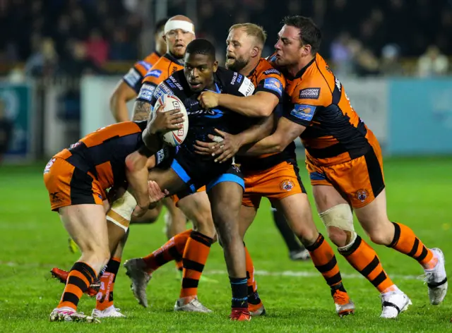 Huddersfield Giants' Jermaine McGillvary is tackled by Castleford Tigers' Paul McShane and Grant Millington