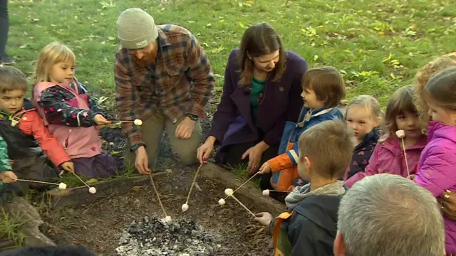 Jo Swinson toasting marshmallows with children