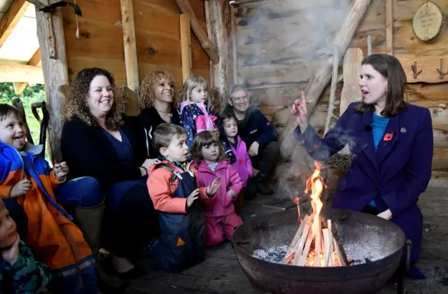 Jo Swinson sat at a campfire