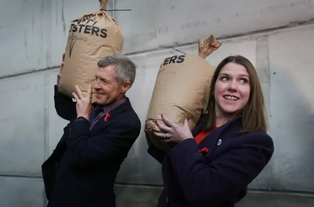 Lib Dem Scotland leader Willie Rennie and Lib Dem leader Jo Swinson hold up sacks of barley during a visit to Crafty Maltsters Scotland