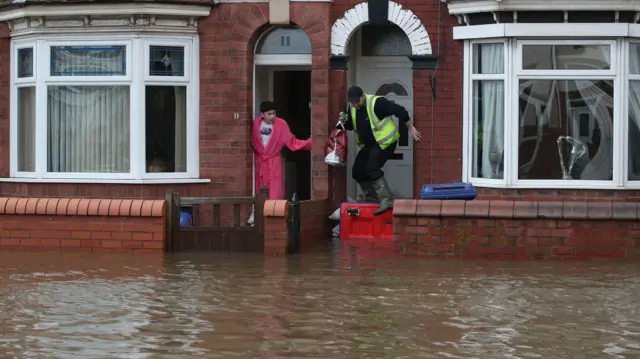 People attempt to walk through flood water in Doncaster