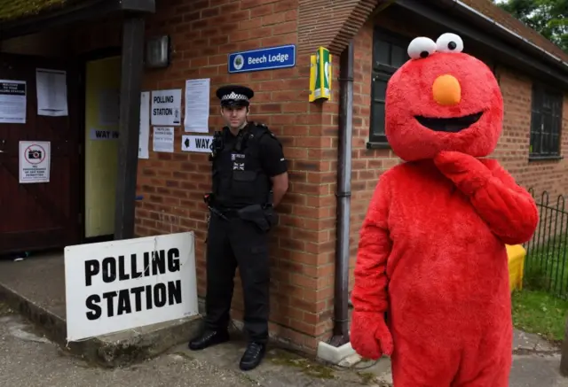 A man dressed as Elmo outside a polling station