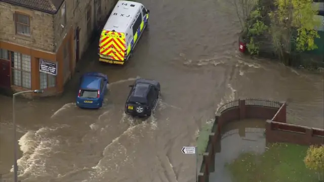 A car drives through floodwater