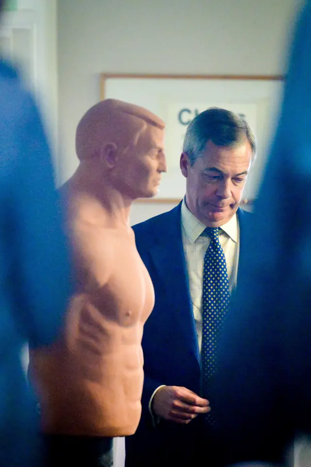 Nigel Farage waits beside a training dummy backstage before speaking at a campaign rally in Pontypool, Wales