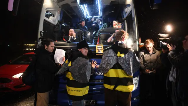 Protesters stuck to front of bus