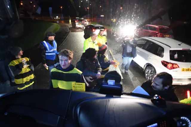 Extinction Rebellion protesters dressed as bees glue themselves to the Conservative Party campaign bus as Prime Minister Boris Johnson visits the JCB cab manufacturing centre in Uttoxeter