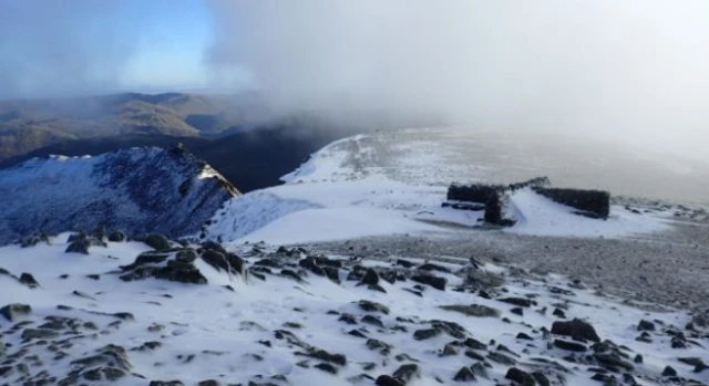 Helvellyn summit shelter with snowdrift