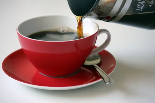 A cup of coffee being poured