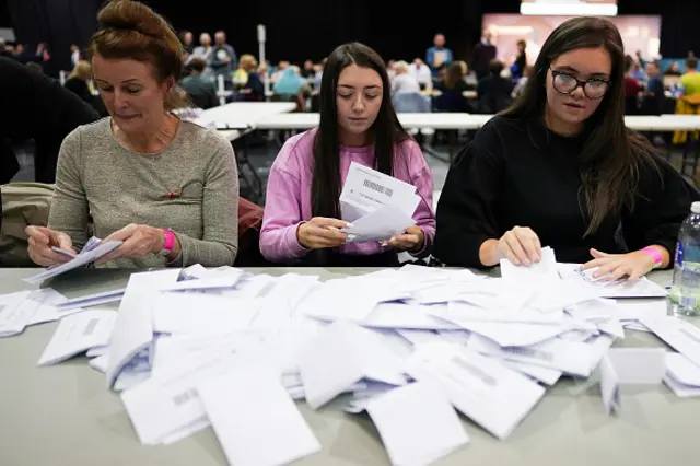 Staff empty ballot boxes at Glasgow counting centres