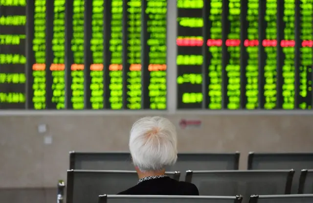 Woman watches a stock market board