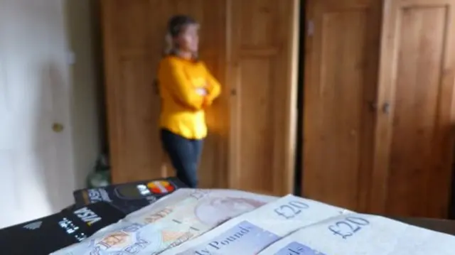 Women standing by cash and cards