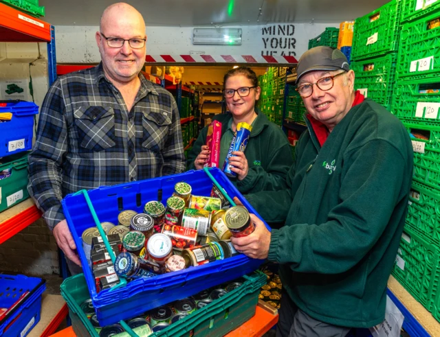 Jim Doherty from BAE, Claiire Coulthurst from the foodbank, and volunteer Ian Platt