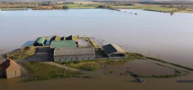 Farm buildings surrounded by water