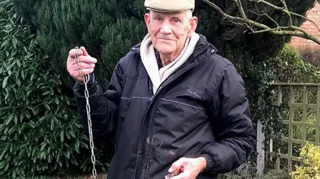 One of the volunteers holding a cut chain after the theft