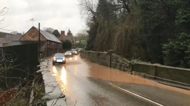 Cars driving around flood water