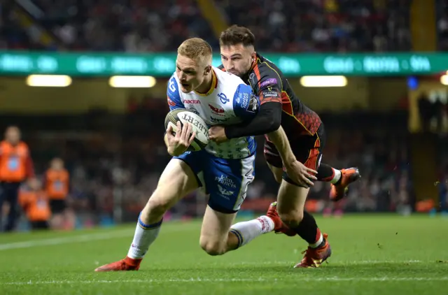 Dragons' Jordan Williams tackles Johnny McNicholl of Scarlets in April 2019