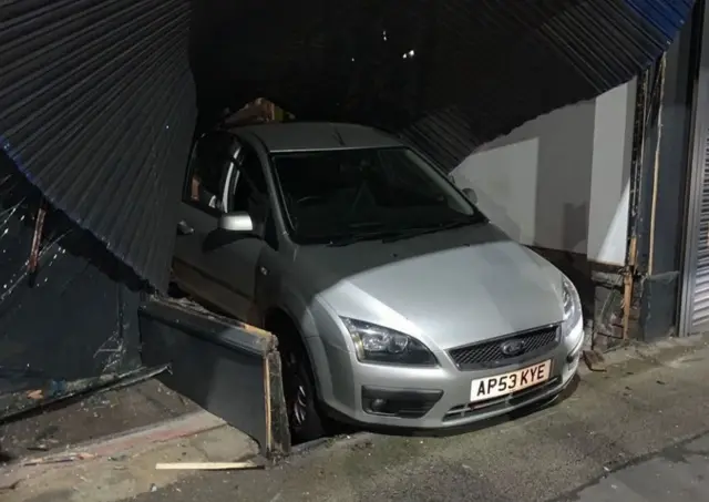 Car through bike shop window