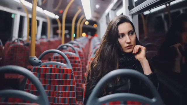 Woman on a bus looking thoughtful