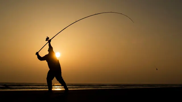 An angler competes in Europe's largest beach angling festival at the Paul Roggeman European Open Beach Championship, in East Riding in Yorkshire.