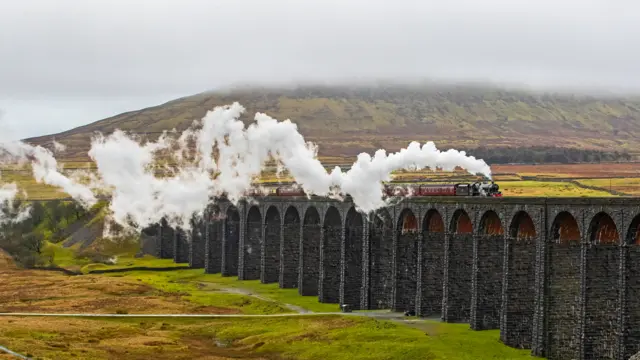 The Winter Cumbrian Mountain Express, hauled by steam locomotive no. 45690 Leander, crosses the Ribblehead Viaduct in North Yorkshire.