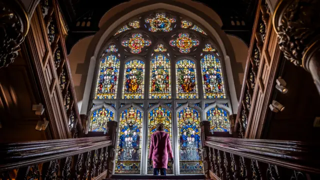 A member of the public stands in front the newly restored Butterfield Window at Cliffe Castle in Keighley, Yorkshire, following the completion of a ten year project to restore the window and staircase at the castle.