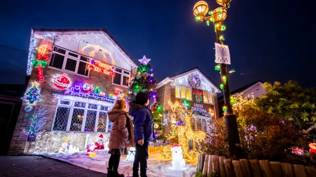 People look at the Christmas display on Stone Brig Lane in Rothwell, Yorkshire, as houses on the street are illuminated by Christmas lights during an event that has become know as the Stone Brig Lights.