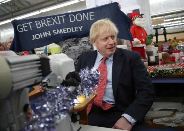 Boris Johnson uses a sewing machine as he visits a mill in Matlock, Derbyshire