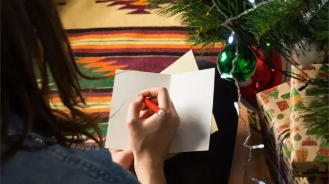 Woman writing Christmas card