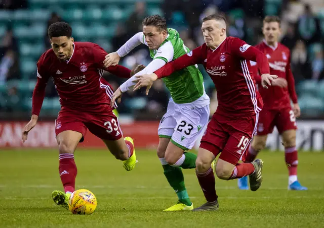 Aberdeen's Zak Vyner (left) and Lewis Ferguson (right) are pictured in action with Hibernian's Scott Allan