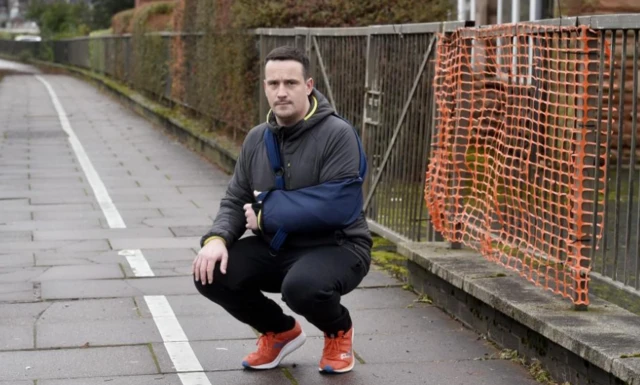 Man next to broken fence