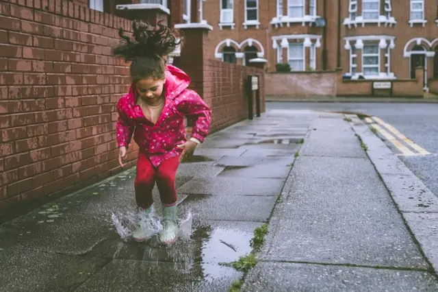 Girl jumping in a puddle