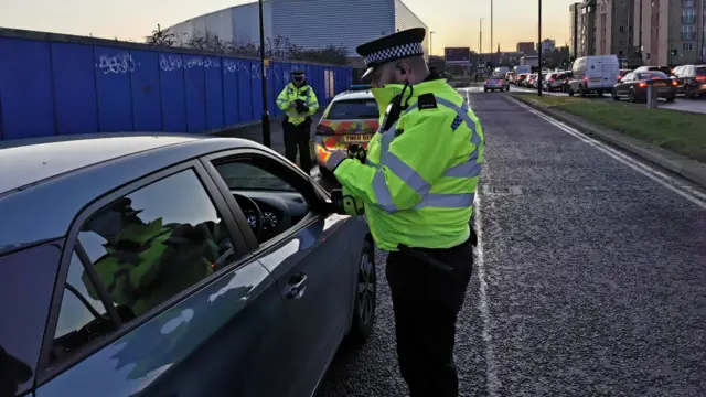 A police officer talks to a driver