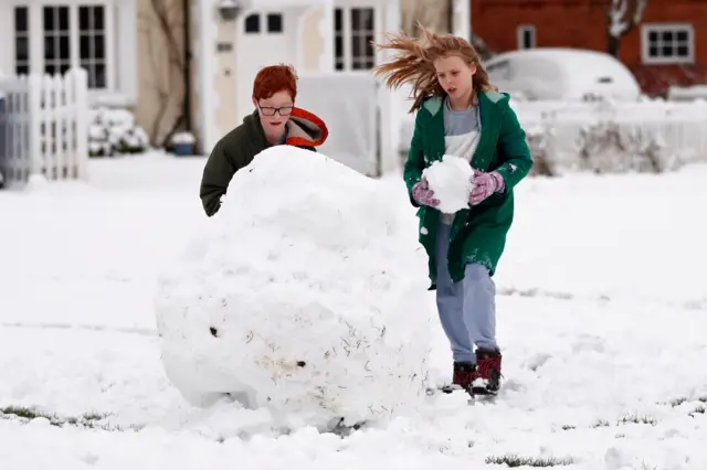 Children play in the snow in Hartley Wintney, in Hampshire, 40 miles west of London