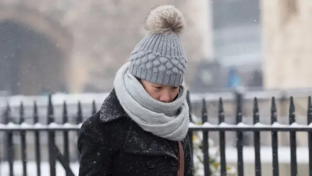 A women is wrapped up in hat and scarf in London