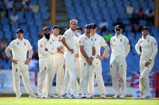 Stuart Broad (c) of England and his team mates await the decision of the Third Umpire