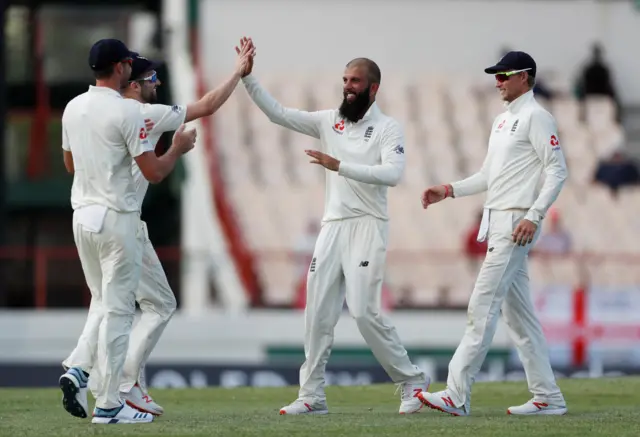 Moeen Ali and James Anderson celebrate the wicket of West Indies' Alzarri Joseph