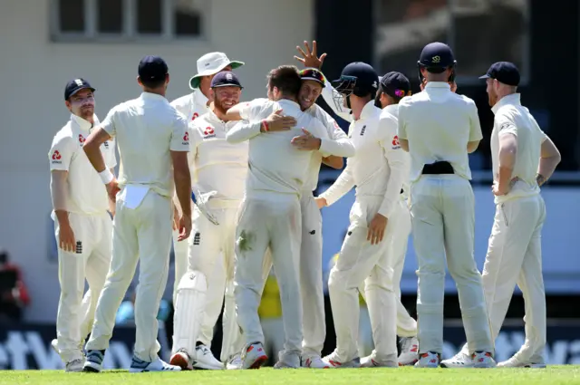 Mark Wood of England (c) is congratulated by Joe Root of England after taking the wicket of Shai Hope