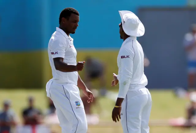 West Indies' Shannon Gabriel celebrates with Kraigg Brathwaite after taking the wicket of England's Joe Root